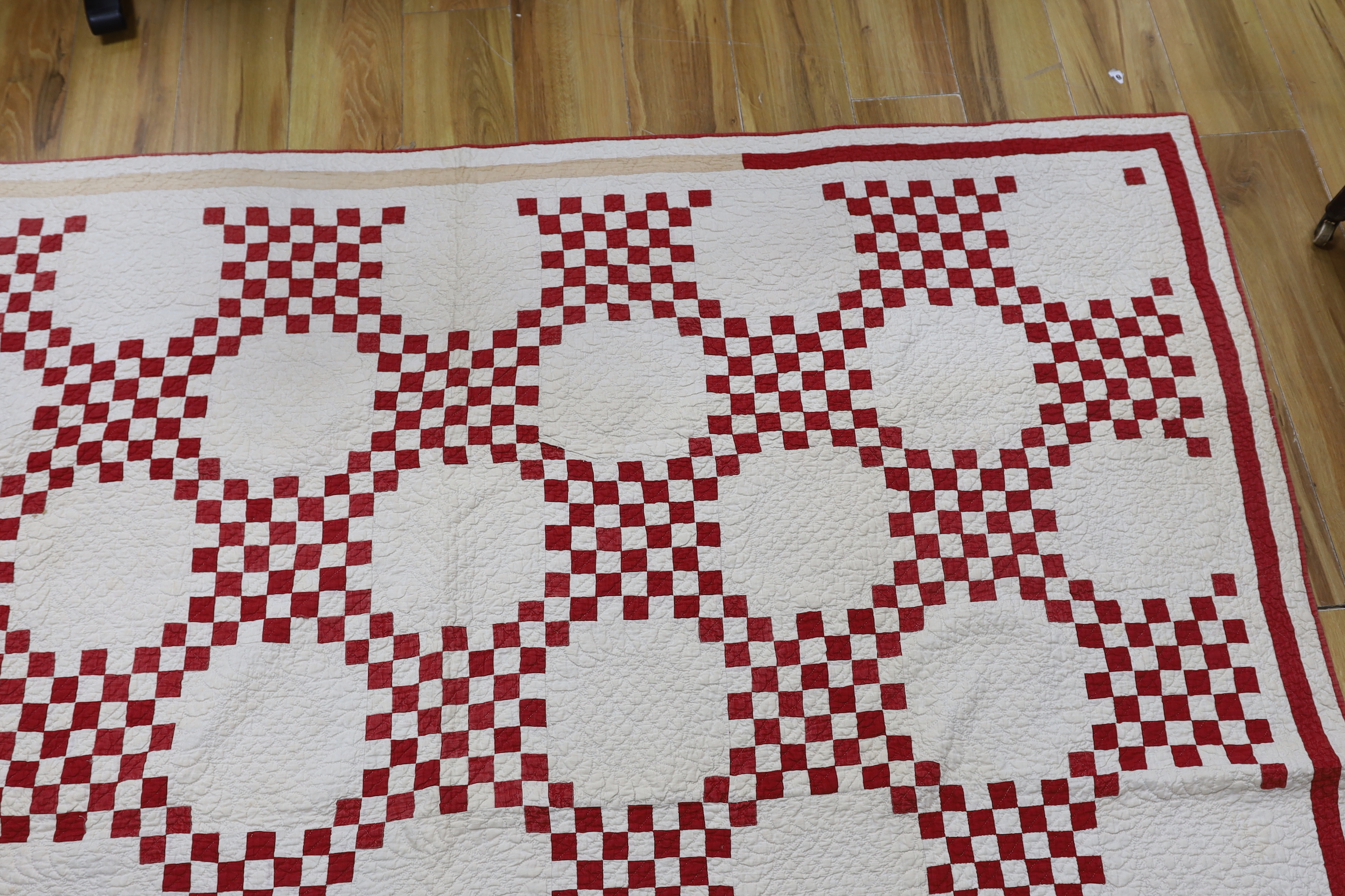 A 19th century Irish chain quilt with red and beige fabric on cream background American